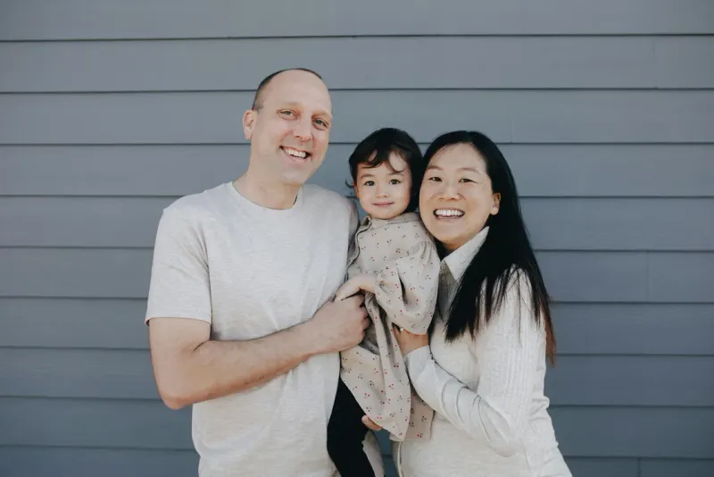 Young family posing together outside their home